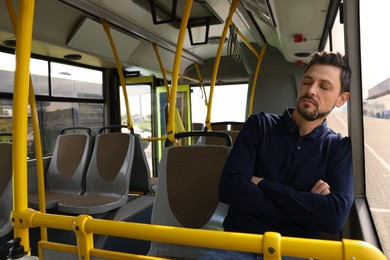 Photo of Tired man sleeping while sitting in public transport