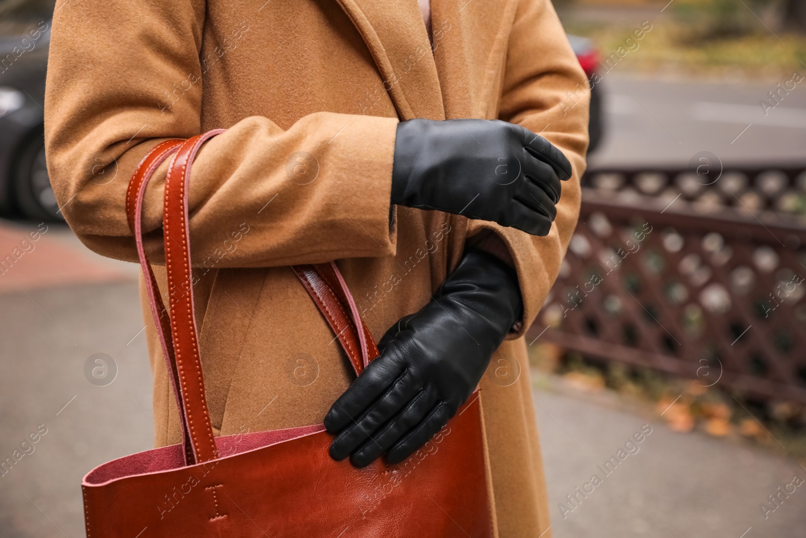 Photo of Young woman in black leather gloves, closeup. Stylish clothes