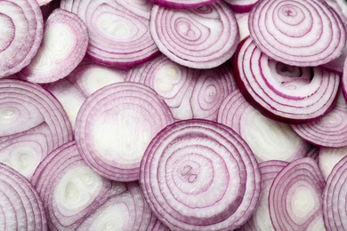 Photo of Cut fresh red onions as background, top view