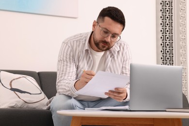 Man doing taxes at table in living room