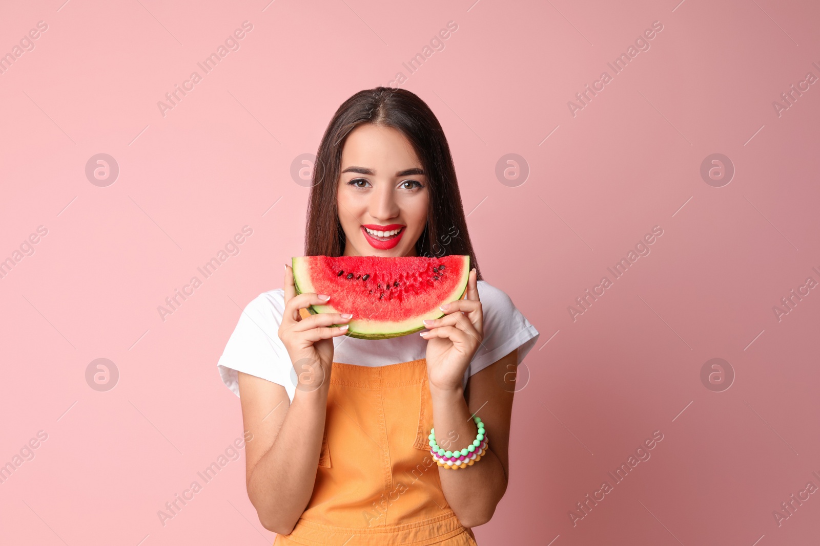 Photo of Beautiful young woman posing with watermelon on color background