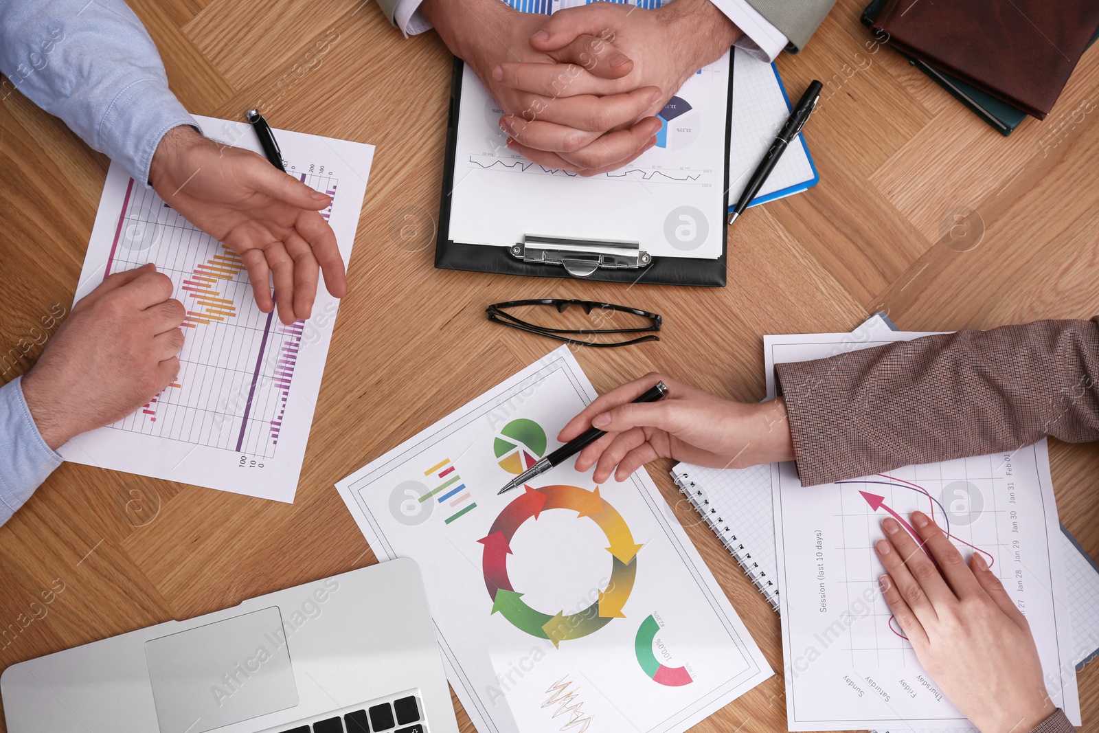 Photo of Business people working with charts and graphs at table, top view. Investment analysis