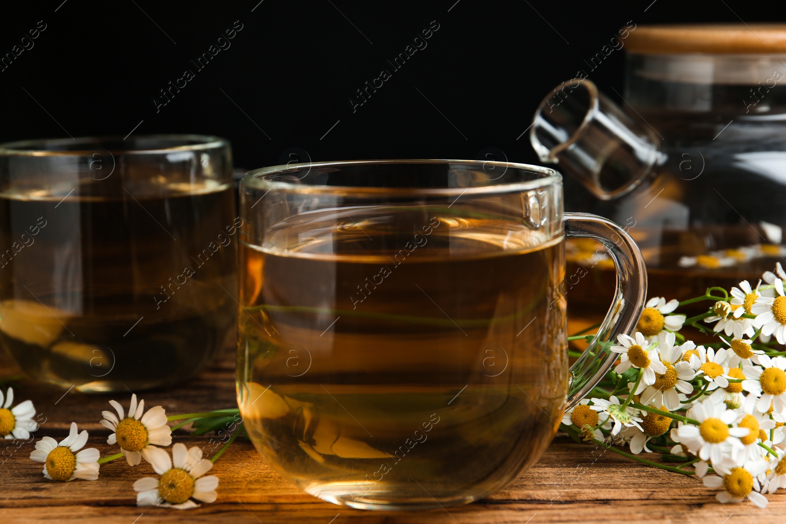 Photo of Cup of tea and chamomile flowers on wooden table