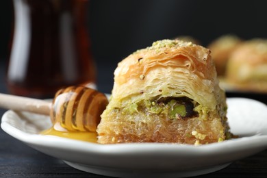Photo of Delicious fresh baklava with chopped nuts and honey on table, closeup. Eastern sweets