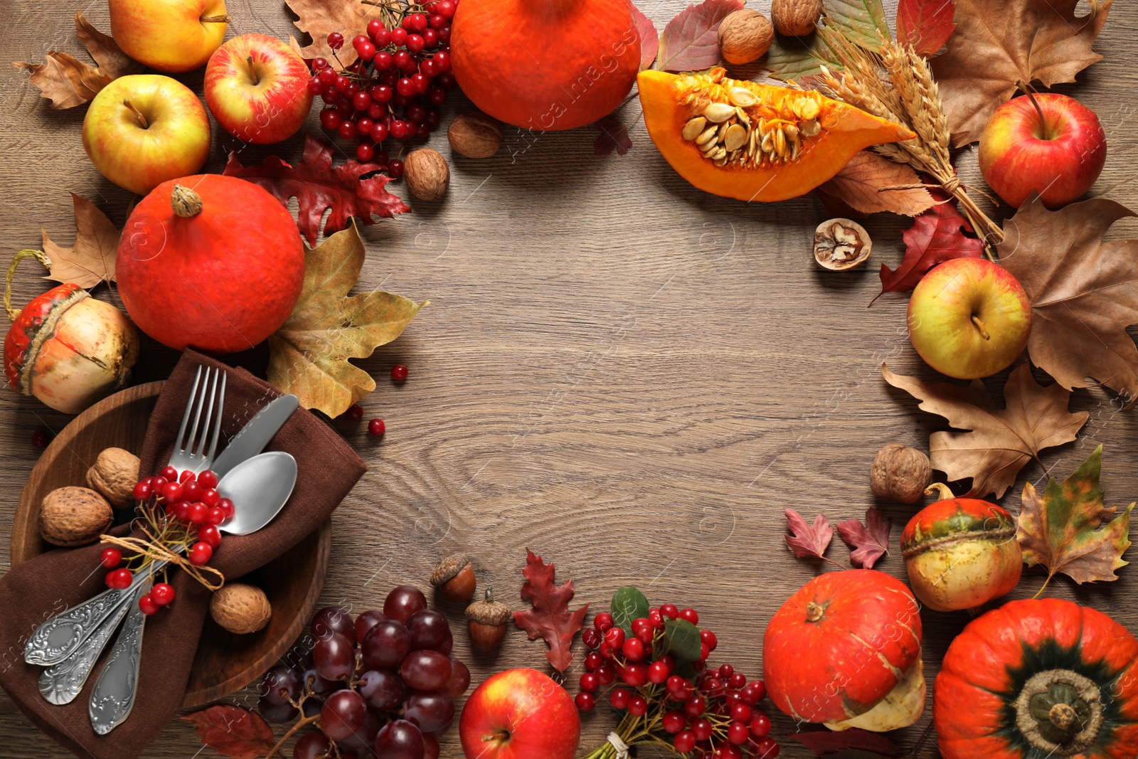 Photo of Frame made of autumn vegetables, fruits and cutlery on wooden background, flat lay with space for text. Happy Thanksgiving day