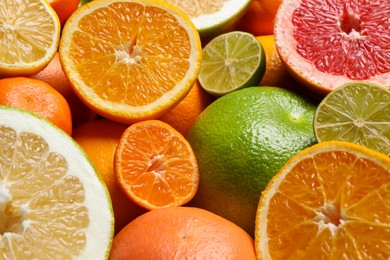 Photo of Different ripe citrus fruits as background, closeup