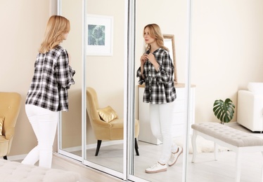 Young beautiful woman near mirror in makeup room