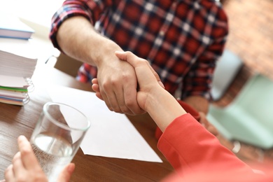 Photo of Business partners shaking hands after meeting, closeup