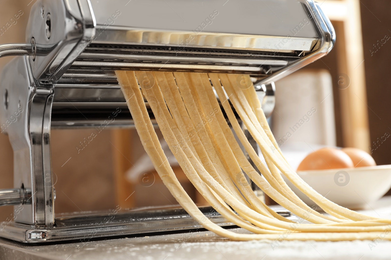 Photo of Pasta maker with dough on kitchen table