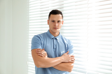 Photo of Handsome young man near window at home