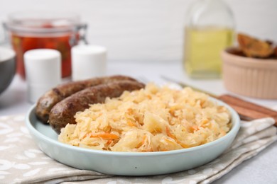 Plate with sauerkraut and sausages on table