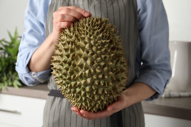 Photo of Woman with fresh durian in kitchen, closeup