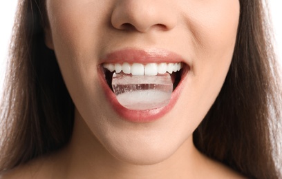 Photo of Young woman holding ice cube in mouth, closeup
