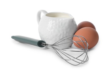 Photo of Whisk, raw eggs and jug of milk isolated on white