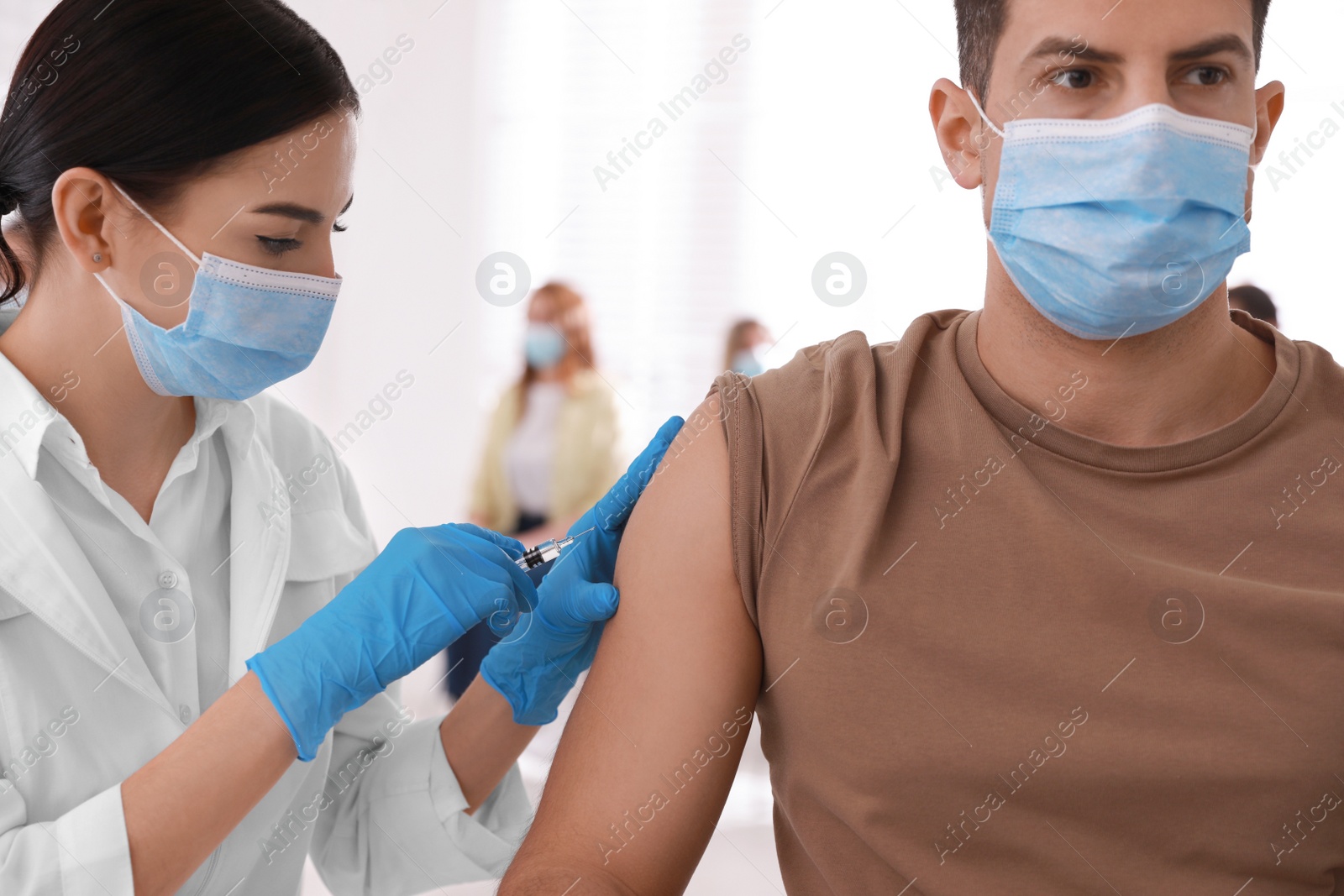 Photo of Doctor giving injection to patient in hospital. Vaccination campaign