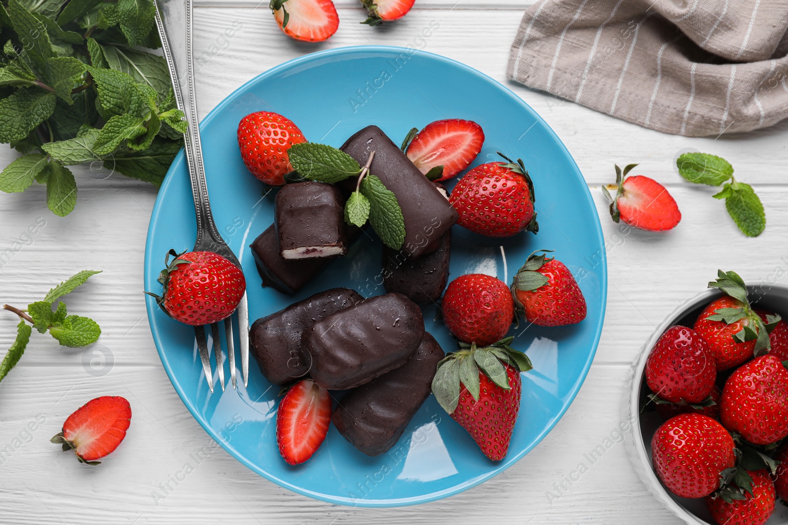 Photo of Delicious glazed curd snacks, mint leaves and fresh strawberries on white wooden table, flat lay