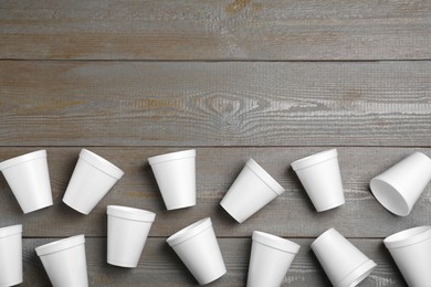 Photo of Many white styrofoam cups on wooden table, flat lay. Space for text