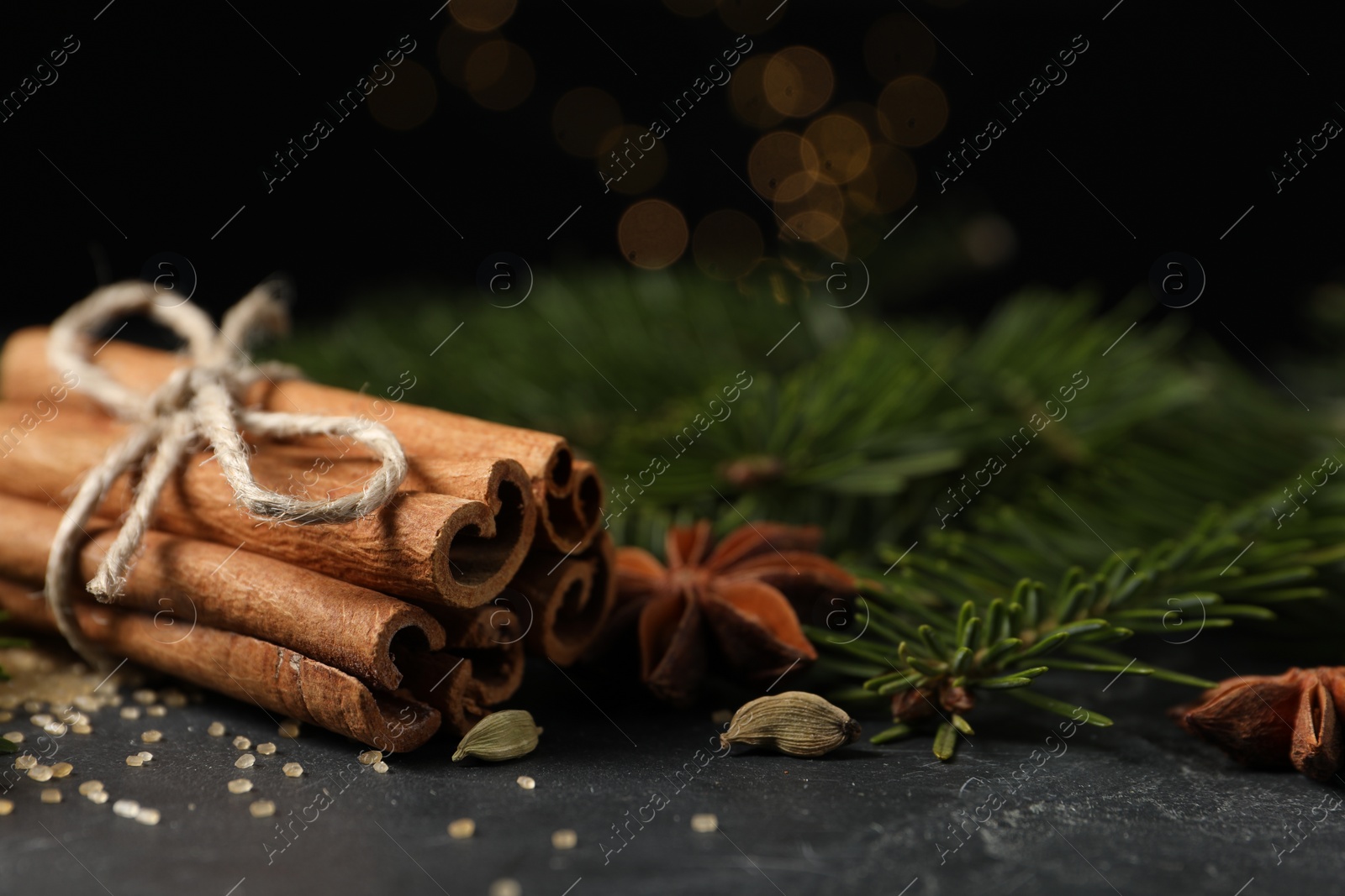 Photo of Different spices and fir branches on gray table, closeup