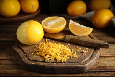 Grated lemon zest and fresh fruits on wooden table