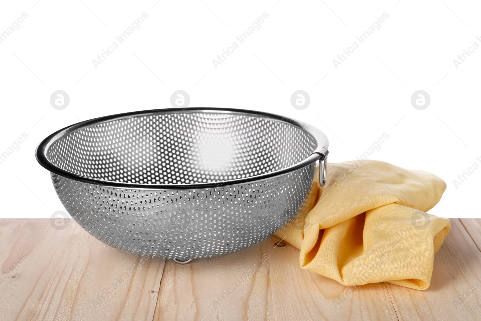 Photo of Metal colander and napkin on wooden table against white background