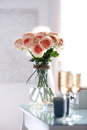 Photo of Glass vase with beautiful flowers on dressing table in modern room interior