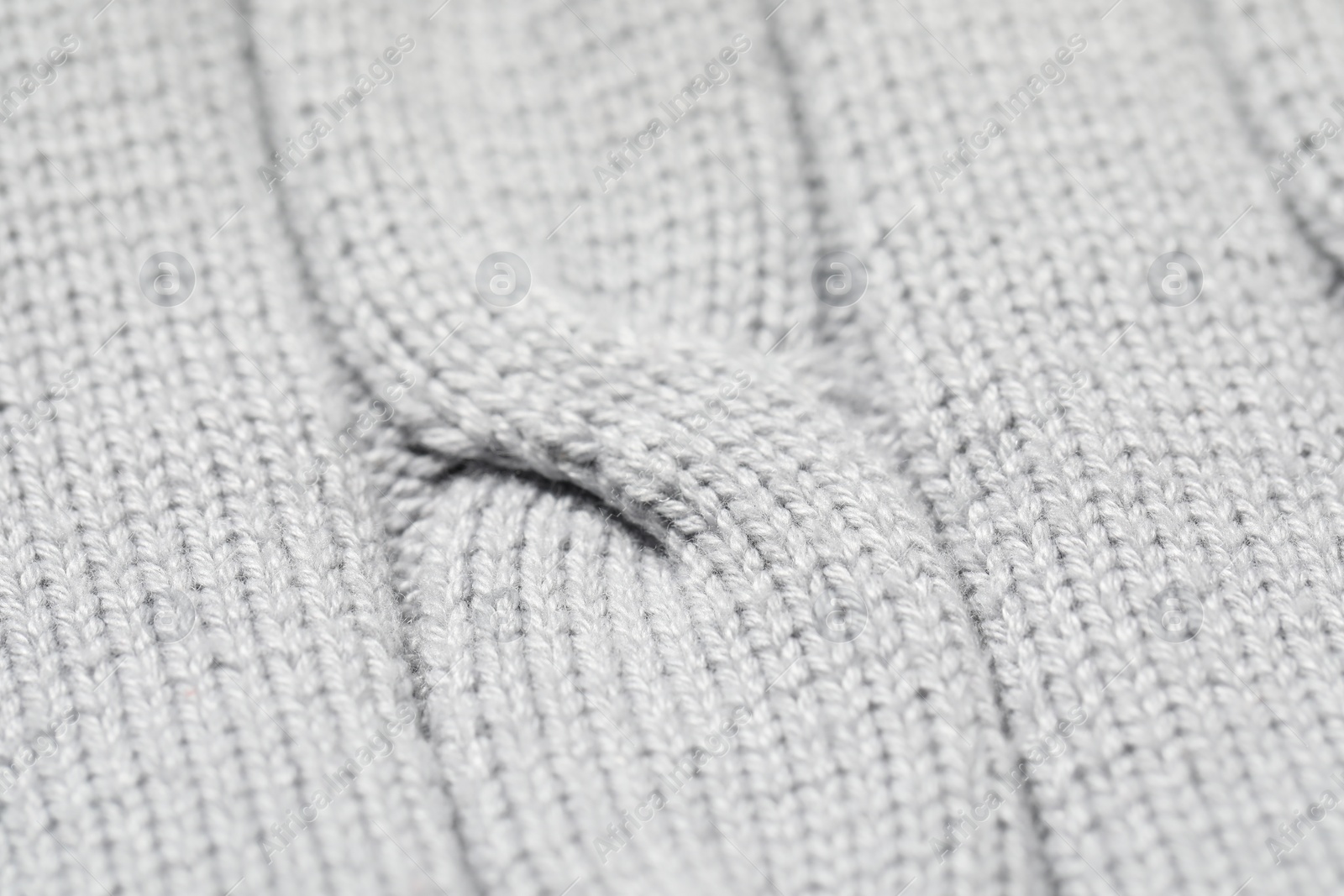 Photo of Texture of soft light knitted fabric as background, closeup