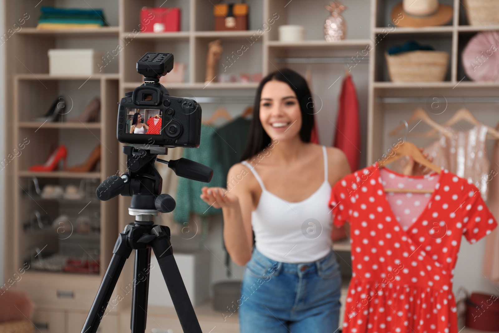 Photo of Fashion blogger recording new video in room, focus on camera