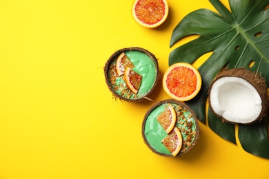 Photo of Coconut shells with yummy spirulina smoothie on color background, top view. Space for text