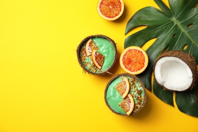 Coconut shells with yummy spirulina smoothie on color background, top view. Space for text