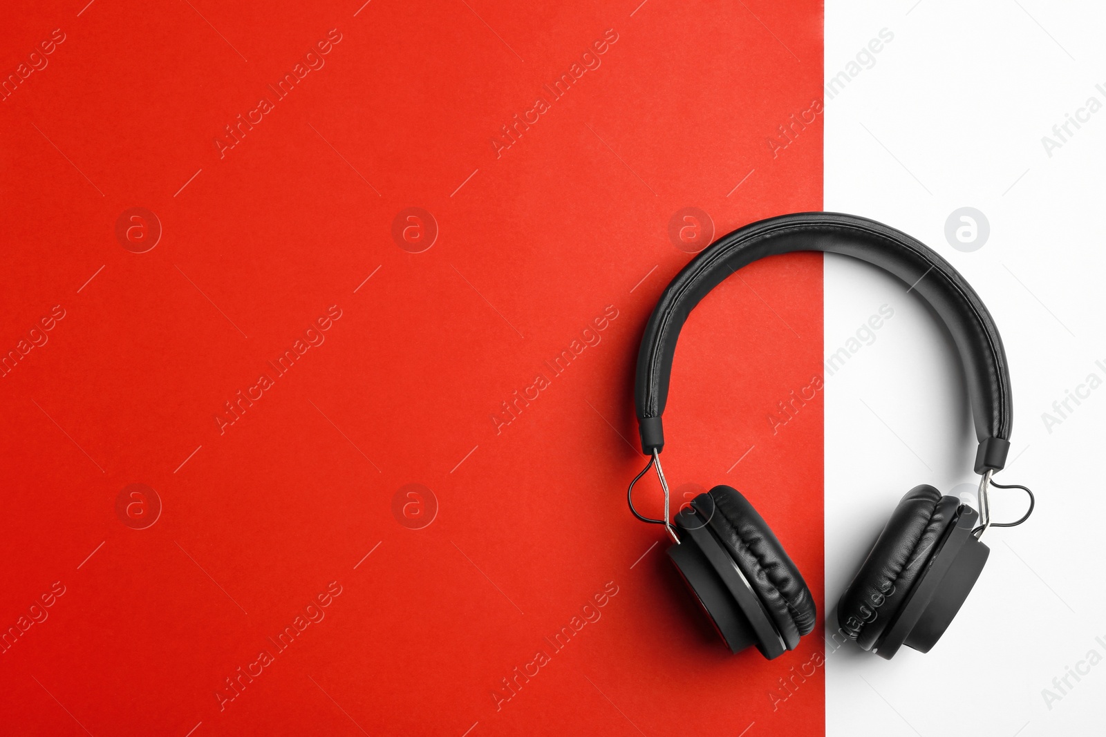 Photo of Stylish headphones on color background, top view. Space for text