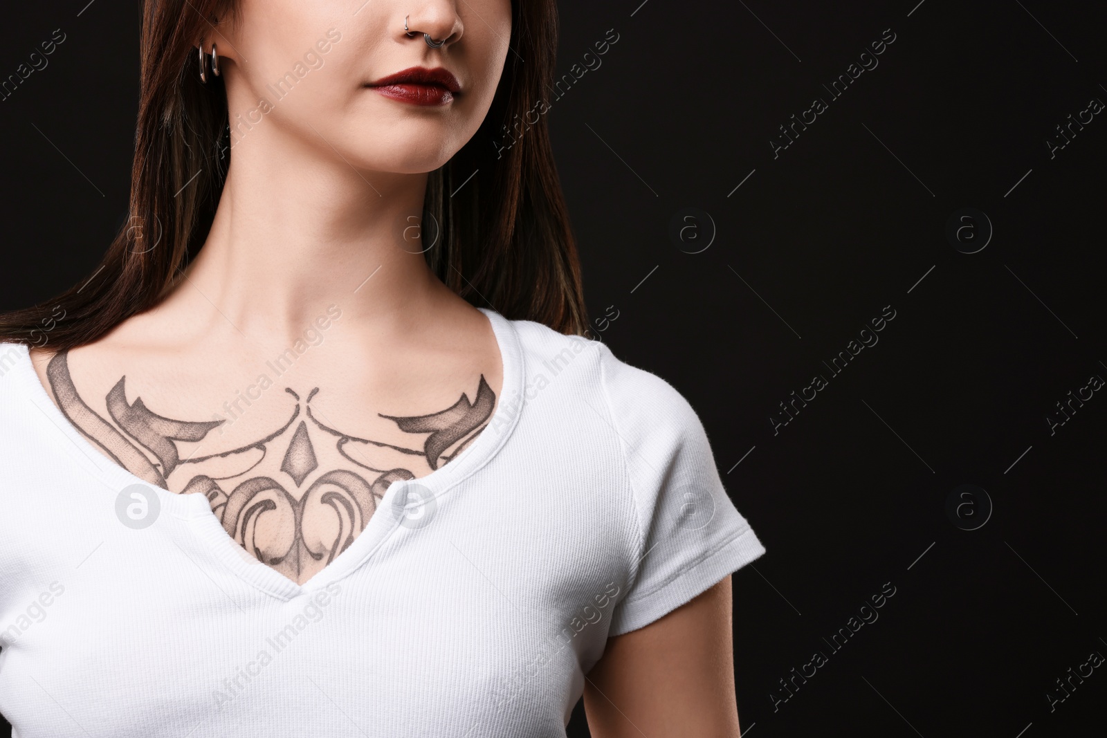 Photo of Woman with cool tattoos on black background, closeup. Space for text