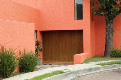 Photo of Beautiful wooden doors on bright building wall