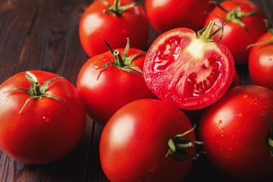 Photo of Fresh ripe tomatoes on wooden table, closeup