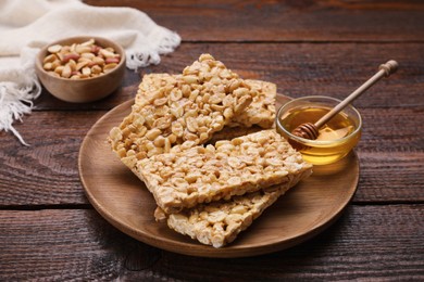 Photo of Delicious peanut bars (kozinaki) and ingredients on wooden table