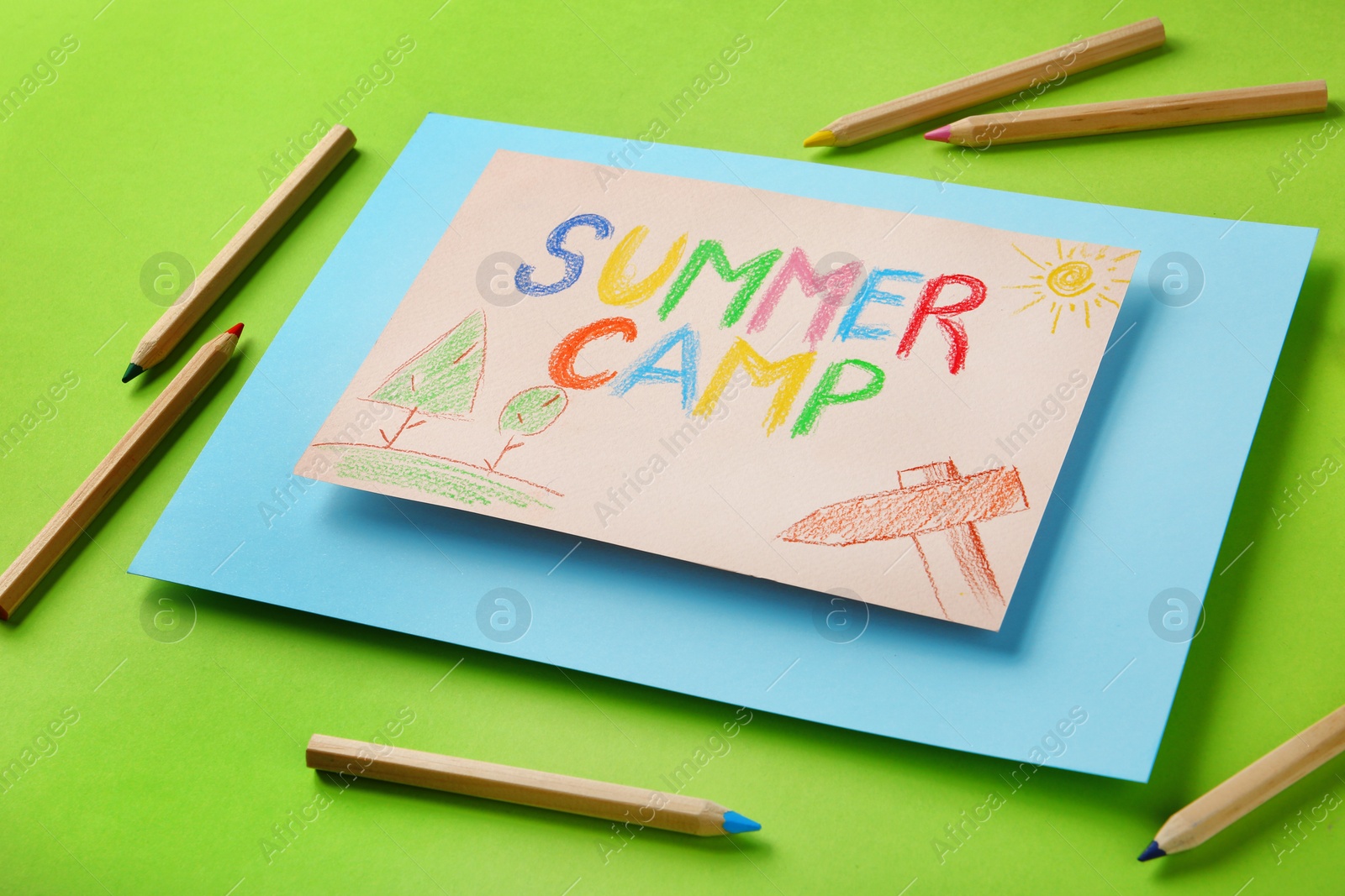 Photo of Paper with written text SUMMER CAMP, drawings and different pencils on color background