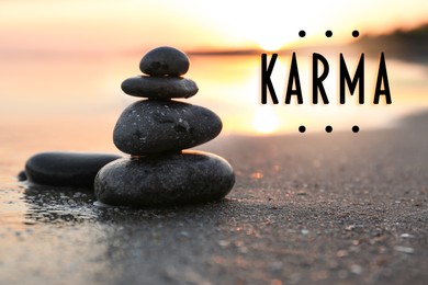 Image of Karma concept. Stones on sand near sea at sunset