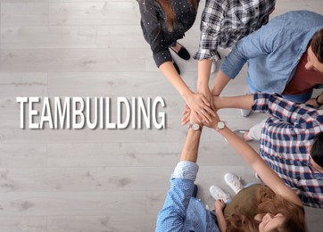 Image of People putting hands together, top view. Team building