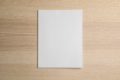 Brochure with blank cover on wooden background, top view. Mock up for design