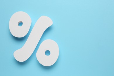 Photo of Percent sign on light blue background, flat lay. Space for text