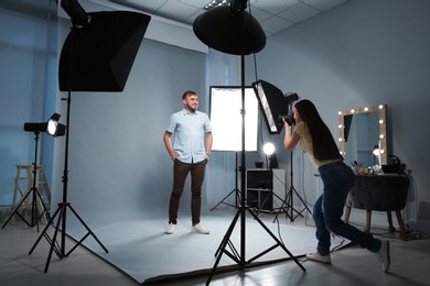 Photo of Handsome model posing for professional photographer in photo studio