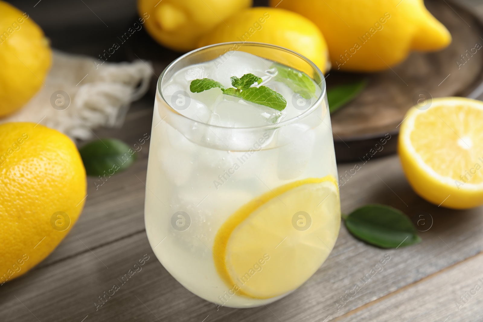 Photo of Cool freshly made lemonade in glass on wooden table, closeup