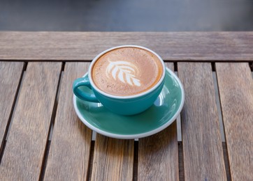 Photo of Cup of aromatic hot coffee on wooden table