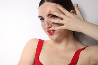 Photo of Beautiful woman with glitter freckles on white background, closeup
