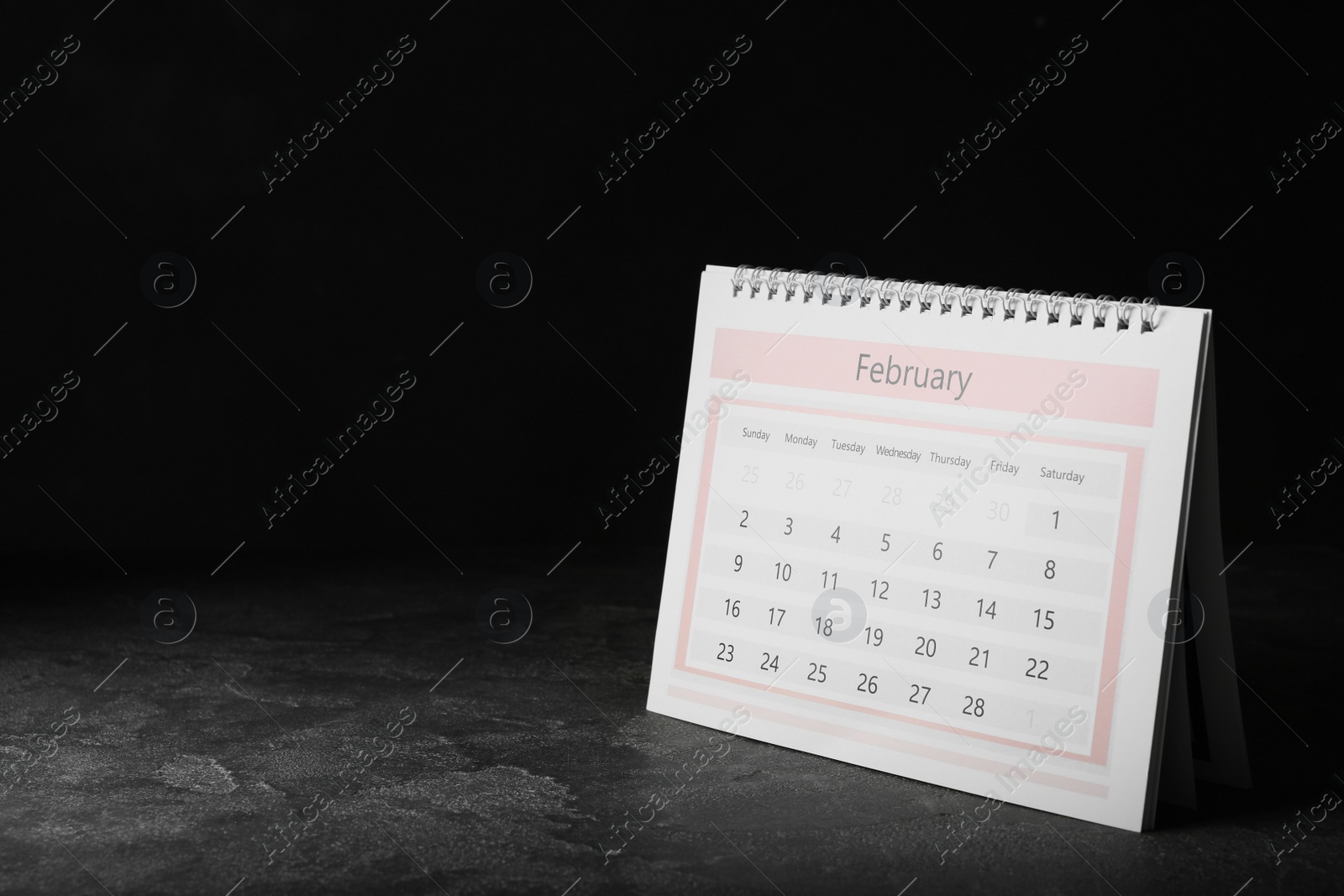 Photo of Paper calendar on grey table, space for text. Planning concept