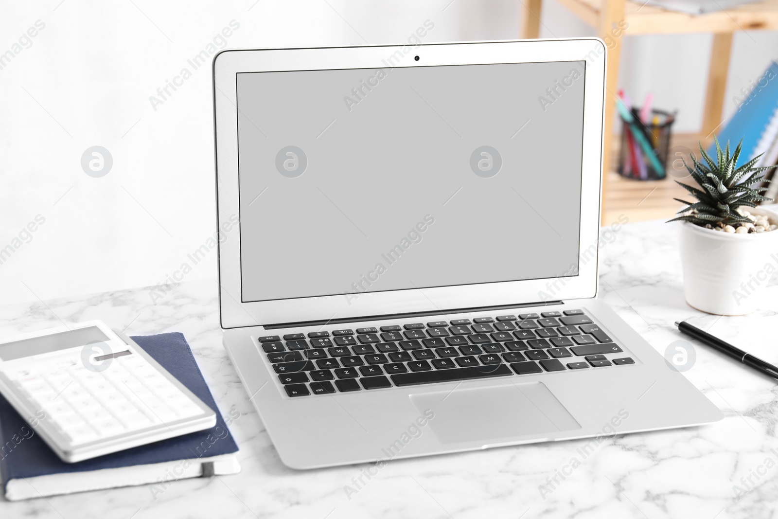 Photo of Modern laptop with blank screen on table in office