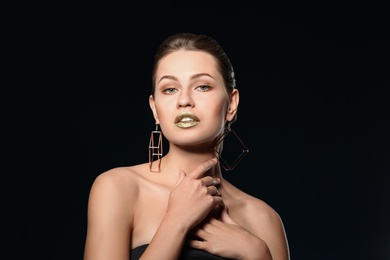 Photo of Portrait of beautiful lady with gold lipstick on black background