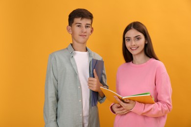 Photo of Teenage students with stationery on yellow background