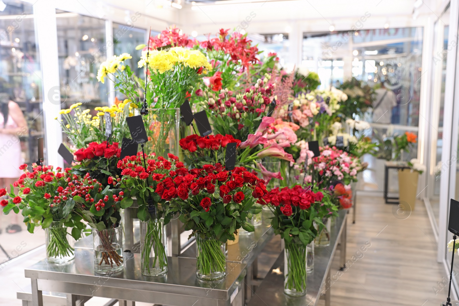 Photo of Assortment of beautiful flowers in shop. Florist's workplace