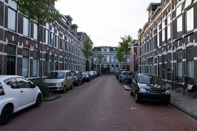 Photo of Many cars parked near houses along street