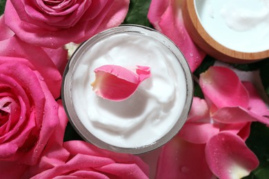 Photo of Jar of face cream among beautiful roses, top view